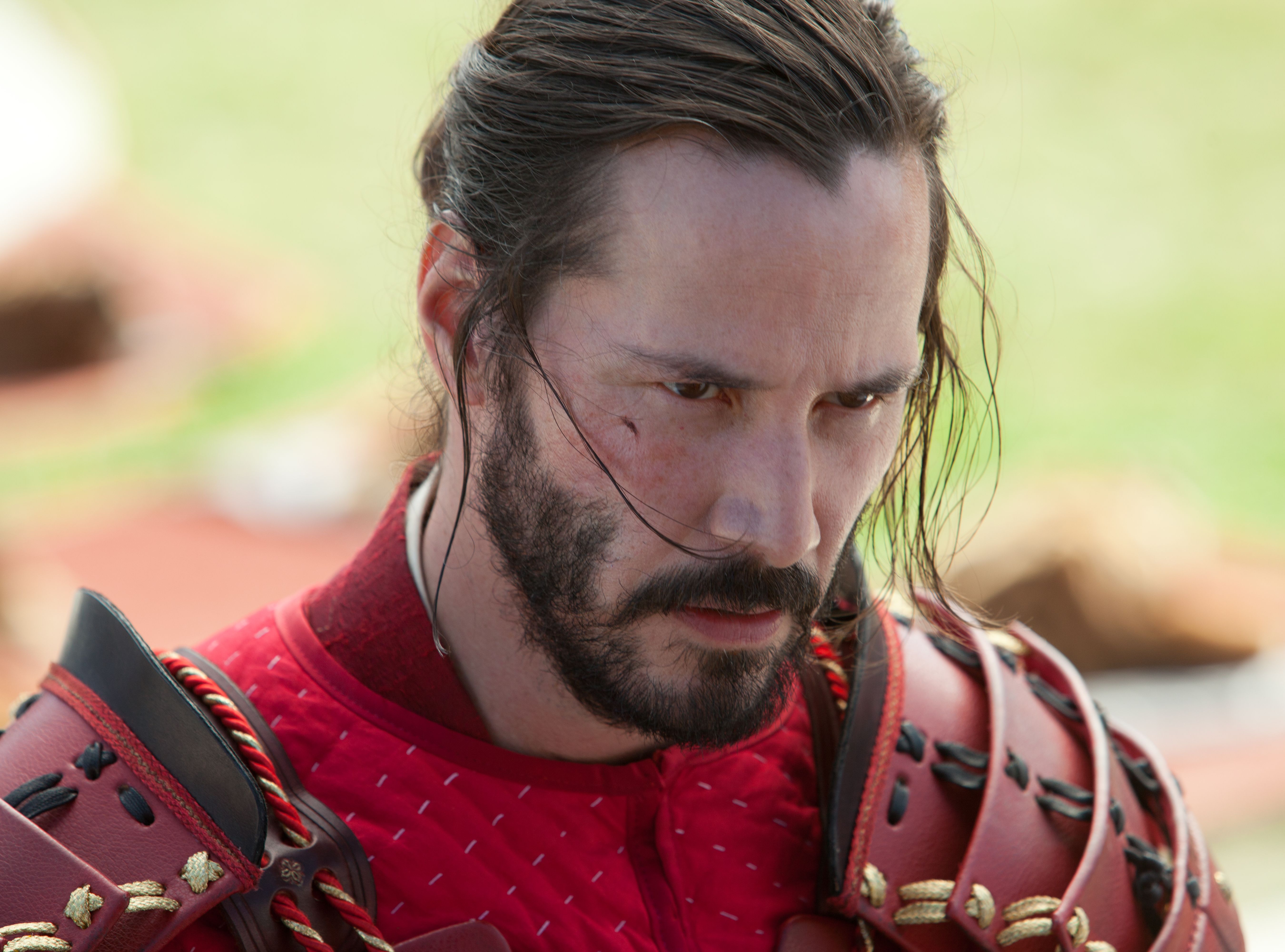 Close-up of Keanu Reeves in red suit as Kai